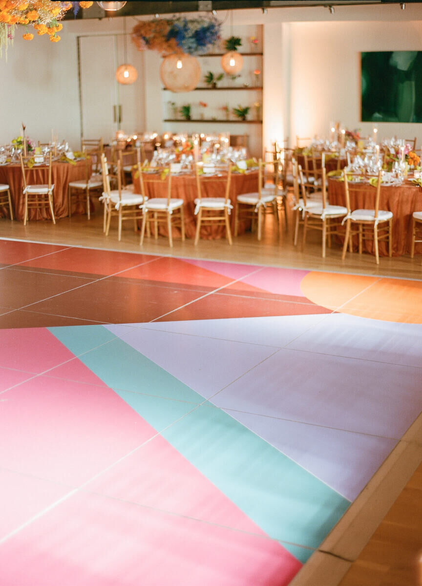 The dance floor of an art-inspired wedding reception was inspired by a painting created by a local artist and boasted a colorful, geometric design.