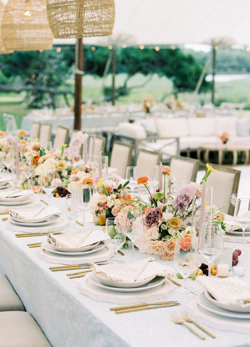 Long tables were decorated with fresh flowers and fruit atop a pale blue linen at this elegant spring wedding.
