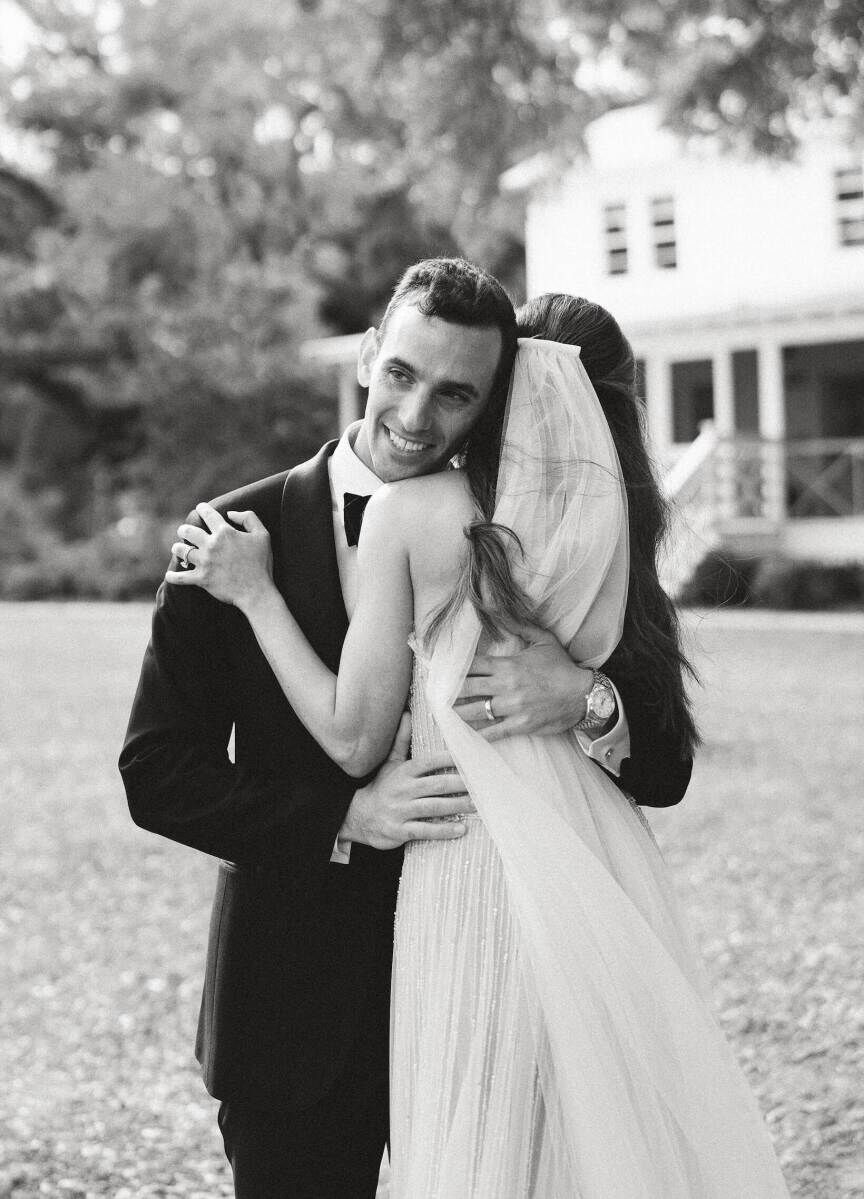 A pair of newlyweds embrace right after their elegant spring wedding ceremony.
