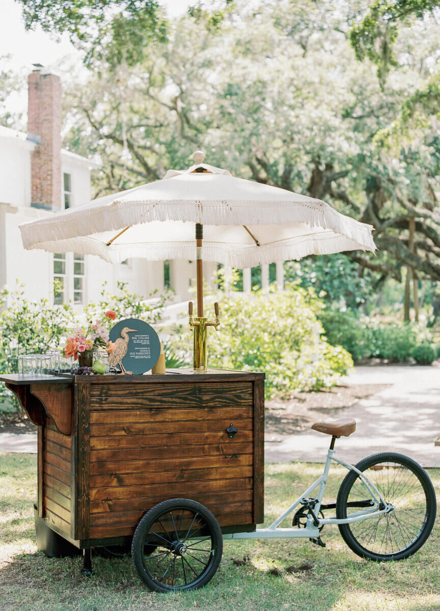 A bike bar cart honored the summer the couple biked around Savannah, at their elegant spring wedding cocktail hour.