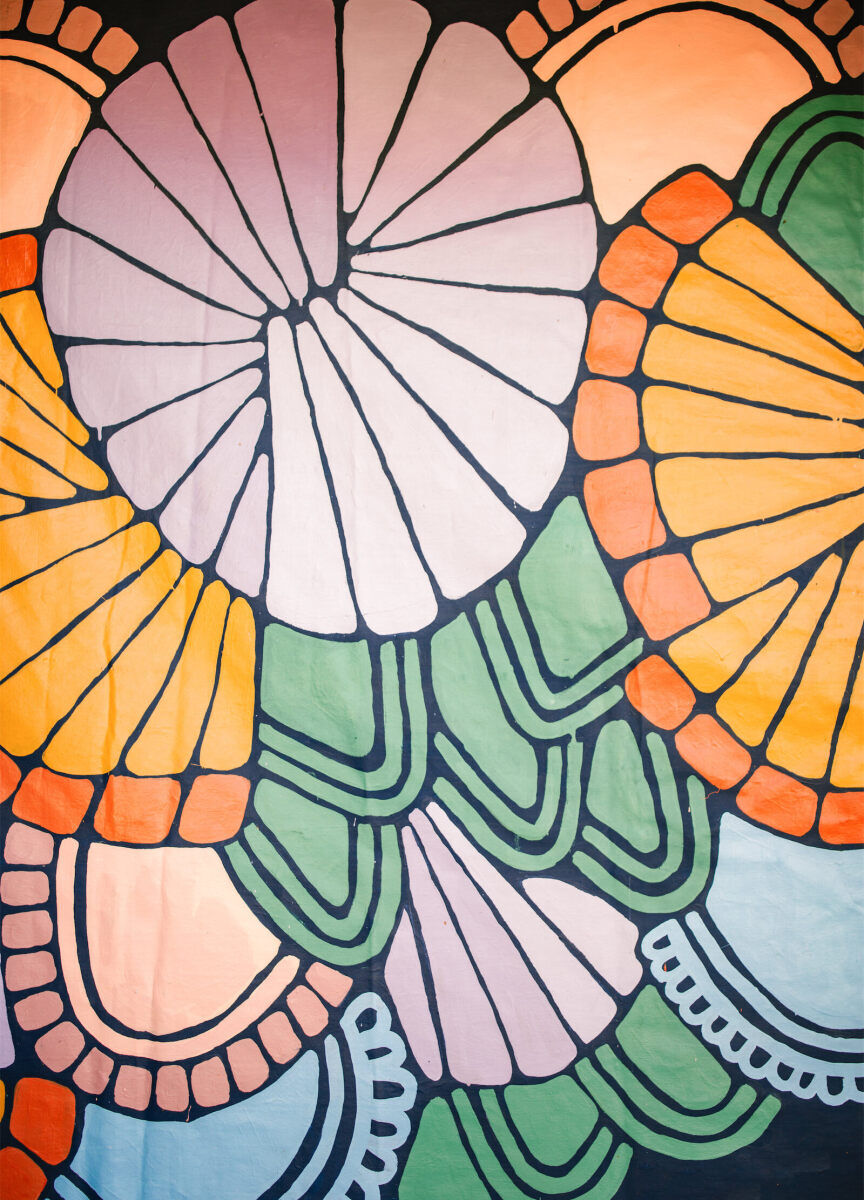 Patterns were painted along the fence of this couple's home, creating an instant color palette for their vibrant, outdoor wedding.