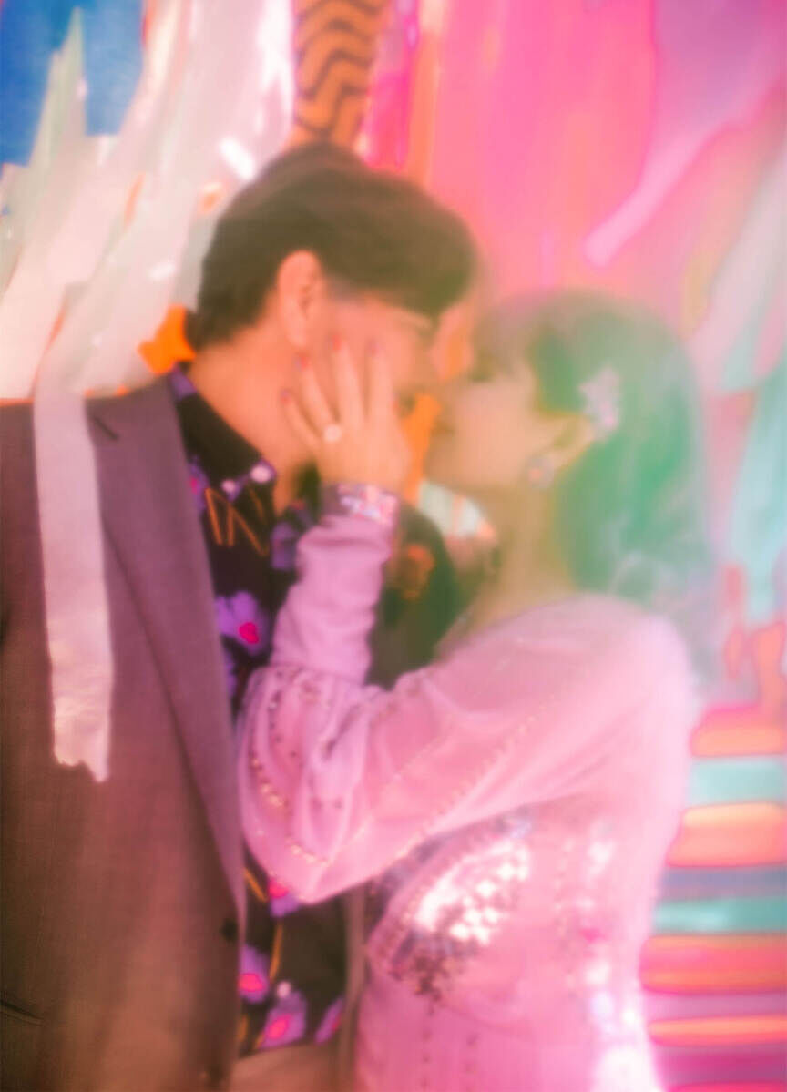 The photographer of this vibrant outdoor wedding captured the bride and groom through the translucency of paper streamers that were part of an art installation. 